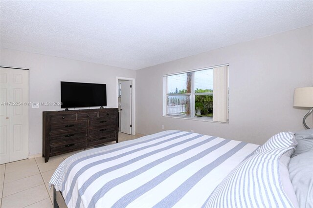 bedroom with light tile patterned floors and a textured ceiling