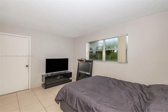 tiled bedroom featuring a textured ceiling