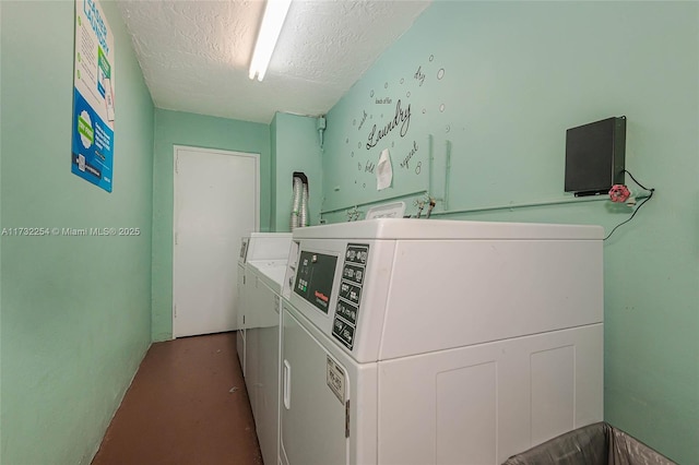 laundry room featuring separate washer and dryer and a textured ceiling