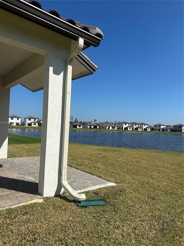 exterior space with a residential view, a water view, and a yard