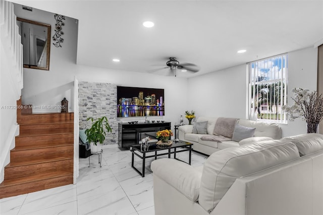 living room featuring a fireplace and ceiling fan