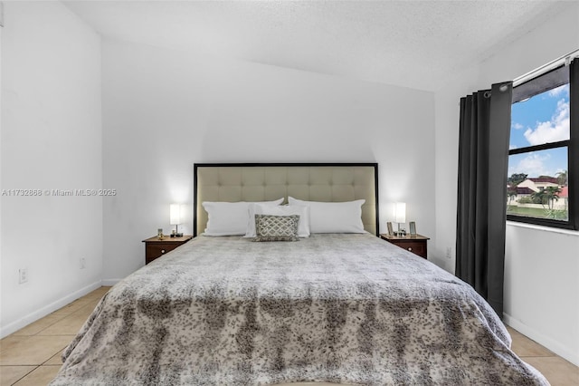 bedroom featuring light tile patterned floors and a textured ceiling