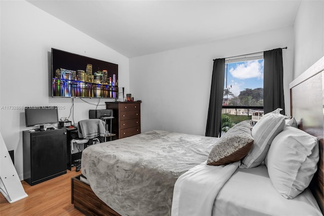 bedroom featuring hardwood / wood-style floors and vaulted ceiling