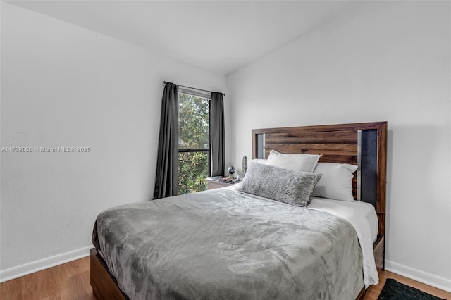 bedroom featuring vaulted ceiling and hardwood / wood-style floors