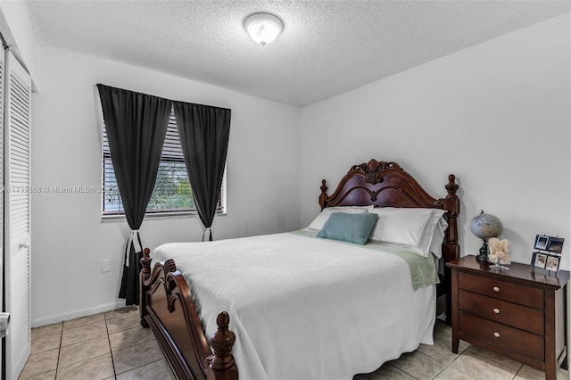 tiled bedroom featuring a closet and a textured ceiling