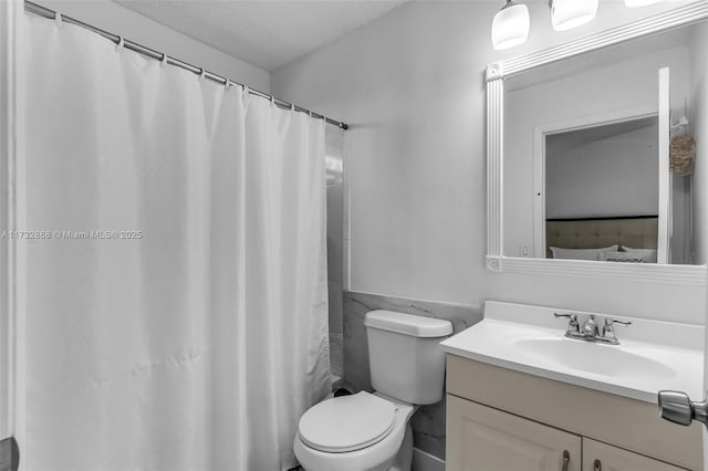 bathroom featuring tile walls, vanity, walk in shower, toilet, and a textured ceiling