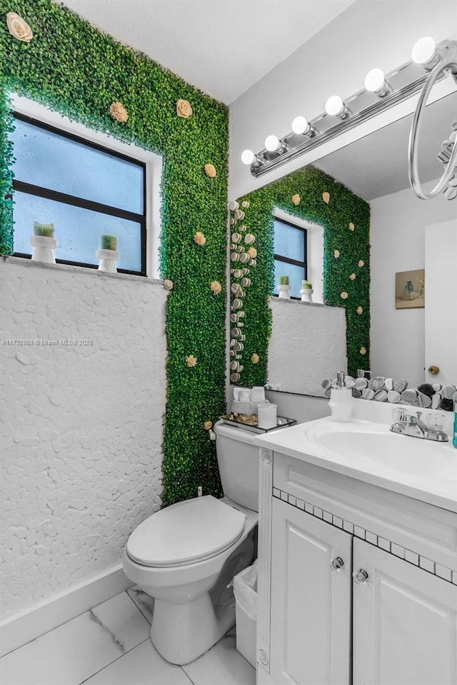 bathroom featuring vanity, a wealth of natural light, and toilet