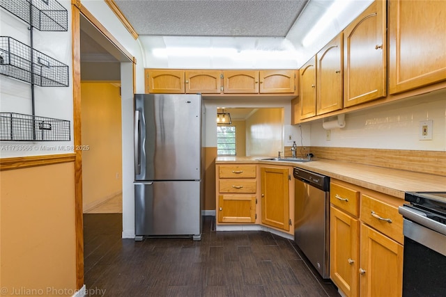 kitchen with dark wood-type flooring, sink, tasteful backsplash, a textured ceiling, and stainless steel appliances