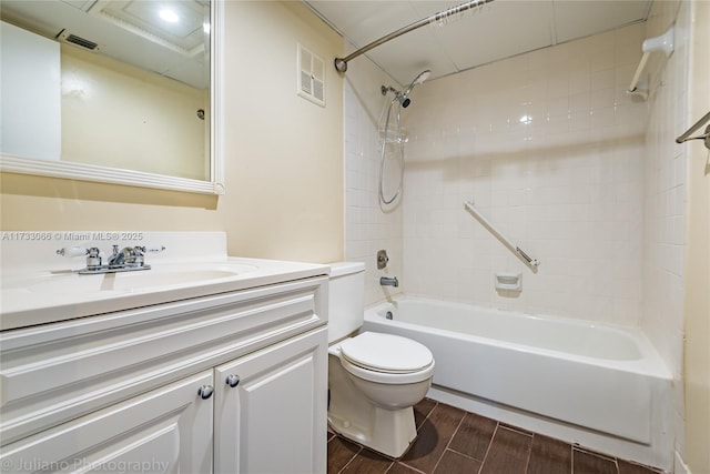 full bathroom with vanity, tiled shower / bath, and toilet