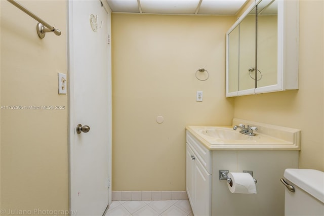 bathroom featuring tile patterned flooring, vanity, and toilet