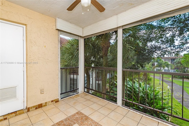 unfurnished sunroom with ceiling fan