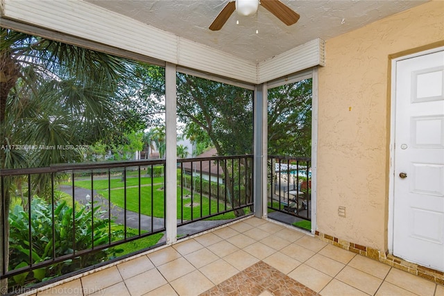 unfurnished sunroom with ceiling fan