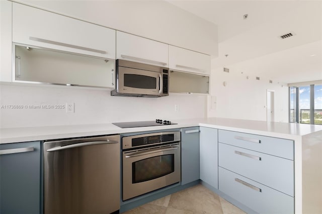kitchen with visible vents, stainless steel appliances, light countertops, modern cabinets, and a peninsula
