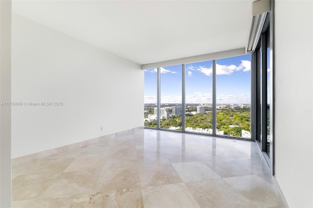 unfurnished room featuring marble finish floor, floor to ceiling windows, and a city view