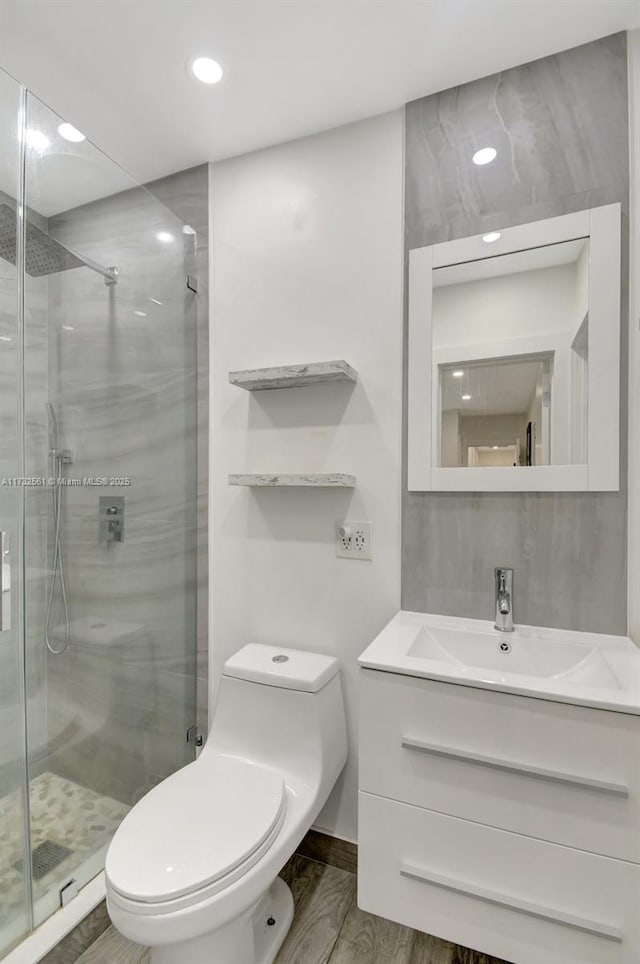 bathroom with vanity, an enclosed shower, and toilet