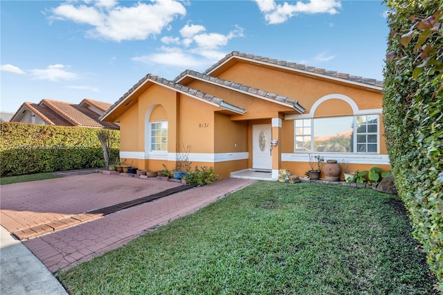 mediterranean / spanish house featuring a front lawn