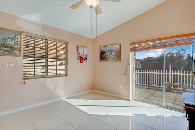 tiled empty room featuring a textured ceiling, vaulted ceiling, and ceiling fan