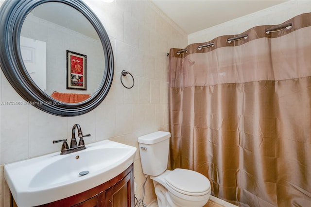 bathroom with vanity, toilet, and tile walls