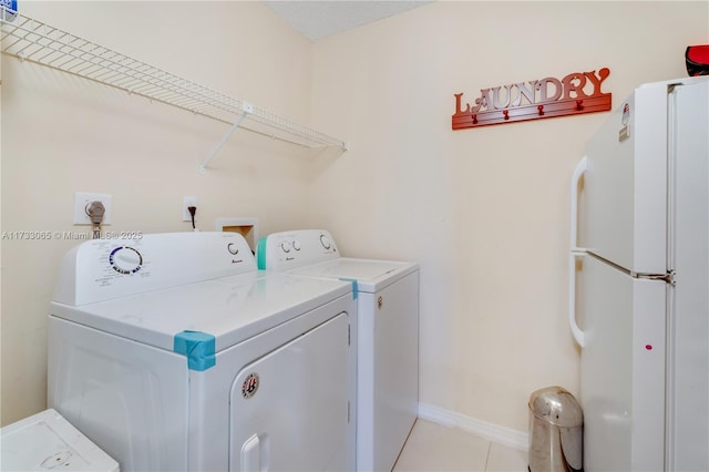 laundry area featuring light tile patterned floors and washing machine and clothes dryer