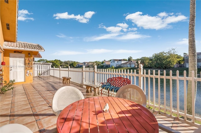 wooden terrace with a water view and a patio area