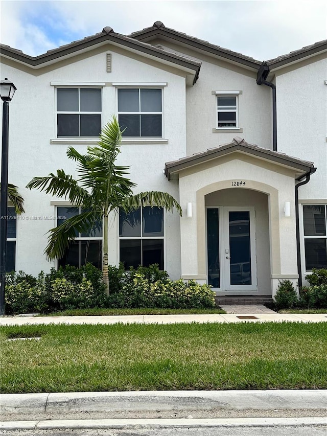 view of front of home featuring a front lawn and french doors