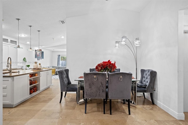 dining room with lofted ceiling and sink