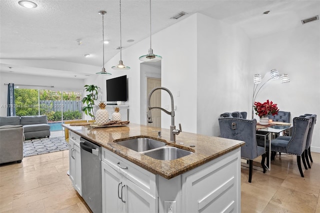 kitchen with vaulted ceiling, sink, white cabinets, a kitchen island with sink, and stainless steel dishwasher