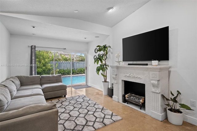 living room with a fireplace, vaulted ceiling, and a textured ceiling