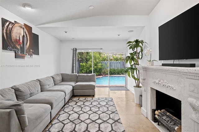 tiled living room featuring lofted ceiling, a high end fireplace, and a textured ceiling