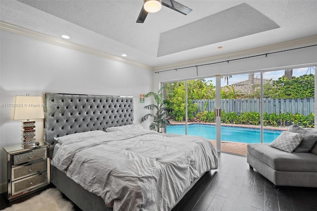 bedroom featuring hardwood / wood-style floors, access to exterior, ceiling fan, a raised ceiling, and a textured ceiling