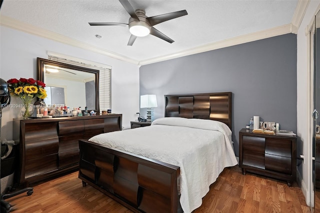 bedroom featuring crown molding, a textured ceiling, dark hardwood / wood-style floors, and ceiling fan