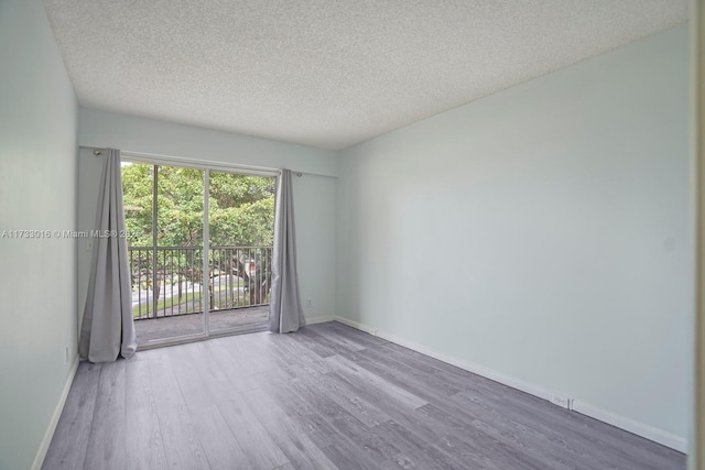 empty room with hardwood / wood-style flooring and a textured ceiling