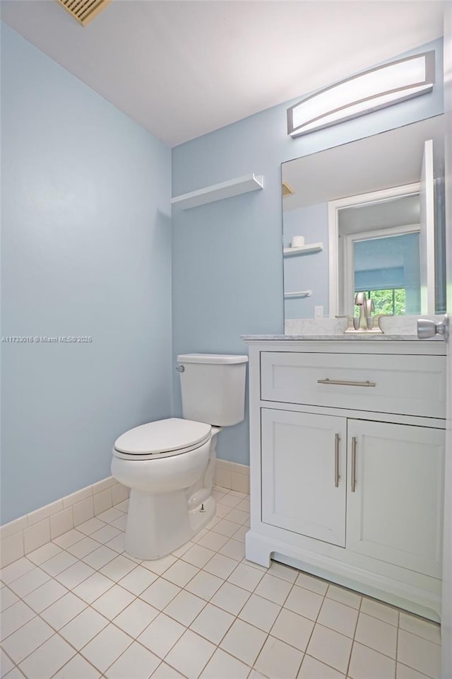 bathroom featuring tile patterned flooring, vanity, and toilet