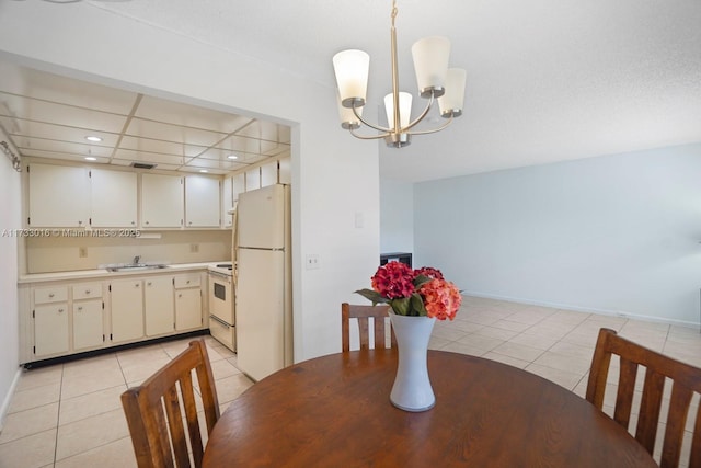 dining area with sink, light tile patterned floors, and an inviting chandelier