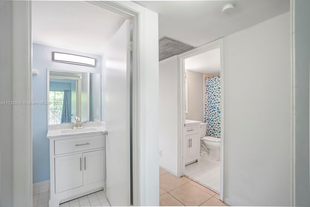 bathroom featuring vanity, tile patterned floors, and toilet