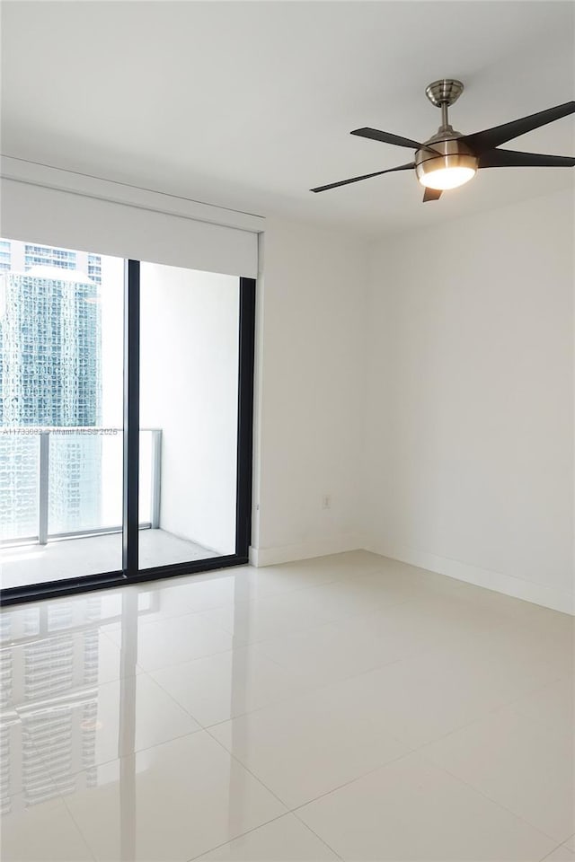 empty room with ceiling fan and light tile patterned floors