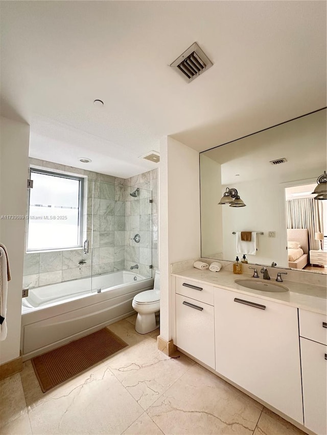 full bathroom featuring vanity, shower / bath combination with glass door, and toilet