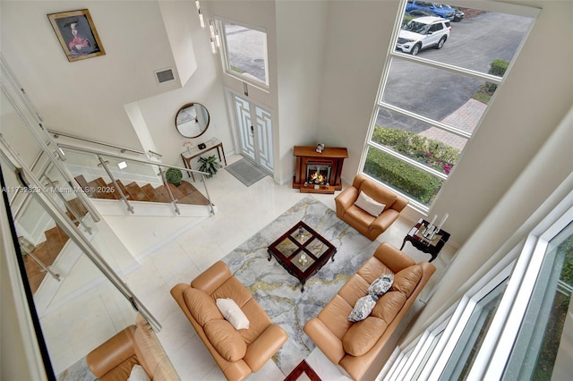 tiled living room featuring plenty of natural light and high vaulted ceiling