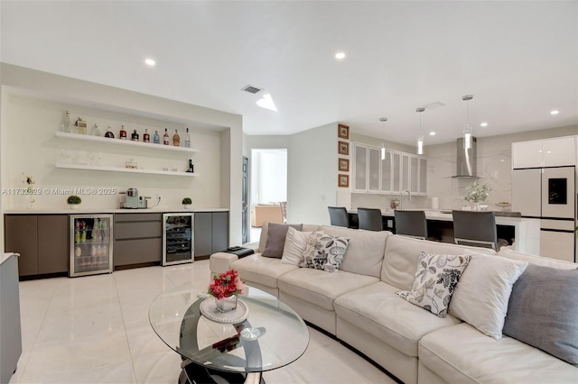 living room with wet bar, beverage cooler, and light tile patterned flooring