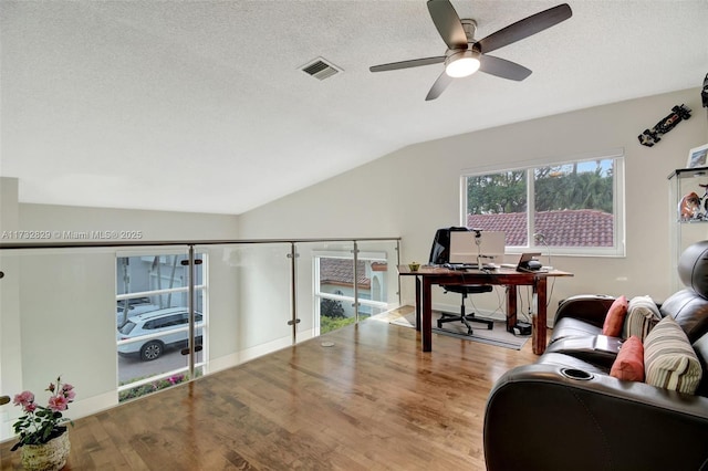 living room featuring vaulted ceiling, wood-type flooring, and a textured ceiling