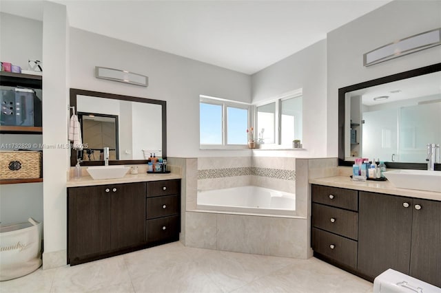 bathroom with vanity, tiled tub, and tile patterned floors