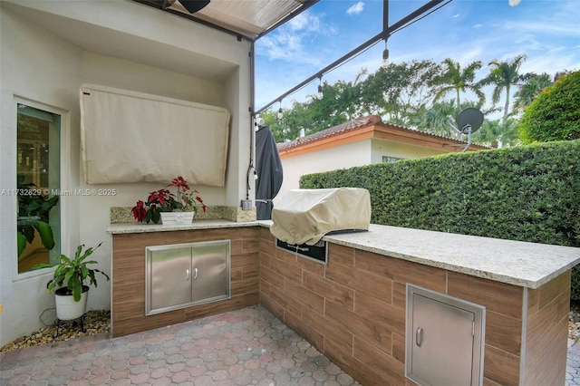 view of patio featuring exterior kitchen, area for grilling, ceiling fan, and a pergola