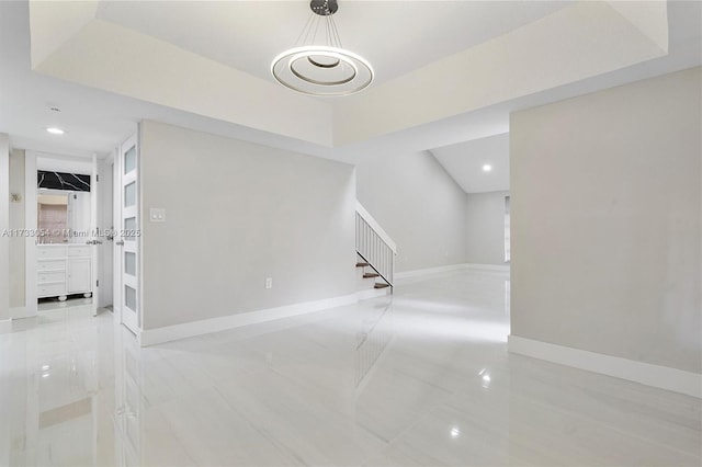 interior space with light tile patterned floors and a raised ceiling