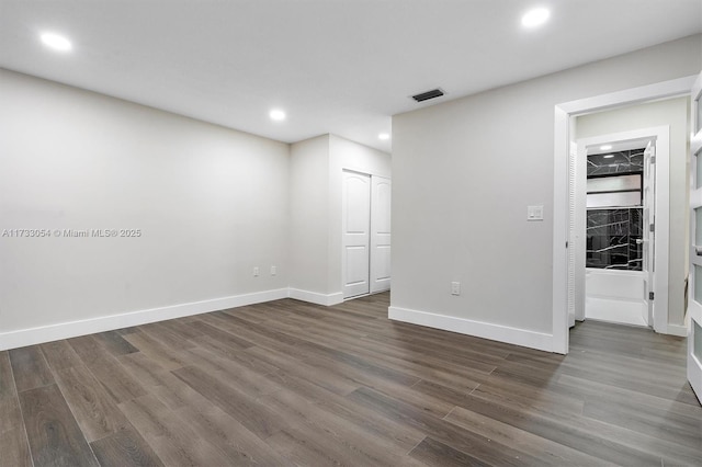 empty room with dark hardwood / wood-style flooring