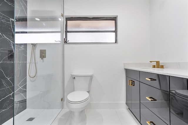 bathroom with tiled shower, vanity, toilet, and tile patterned floors