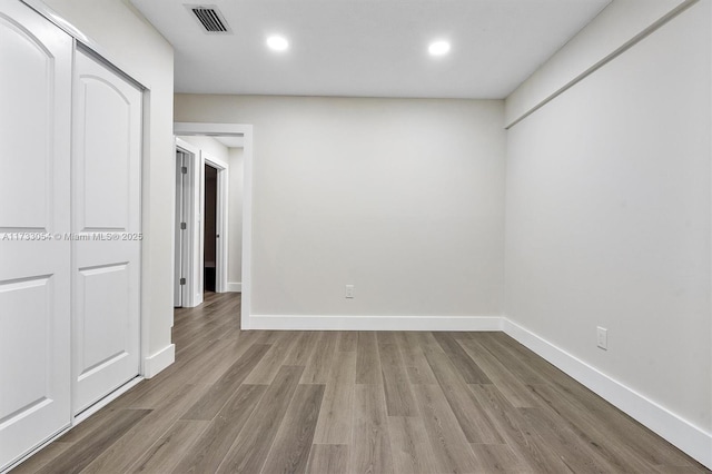 unfurnished bedroom with a closet and light wood-type flooring