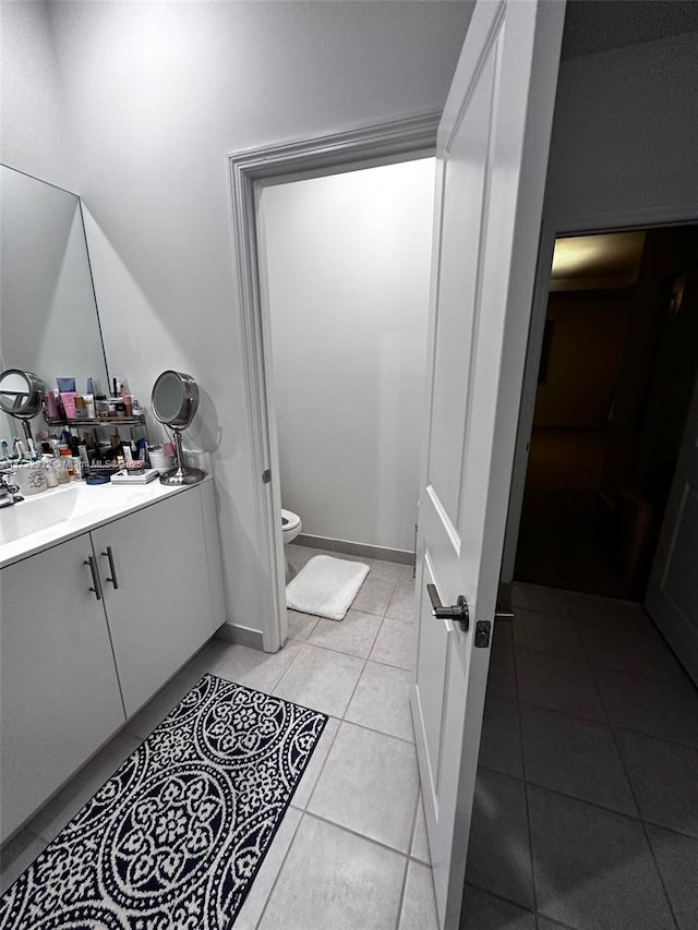 bathroom featuring vanity, tile patterned floors, and toilet