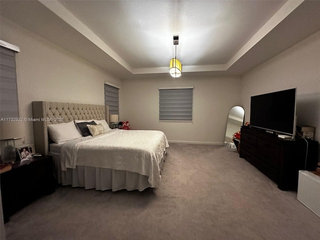 bedroom featuring a tray ceiling and carpet