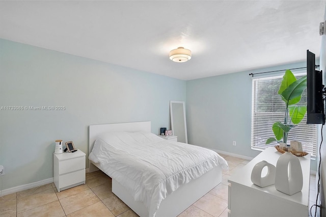 bedroom featuring light tile patterned floors and baseboards