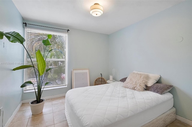 bedroom with light tile patterned flooring and baseboards